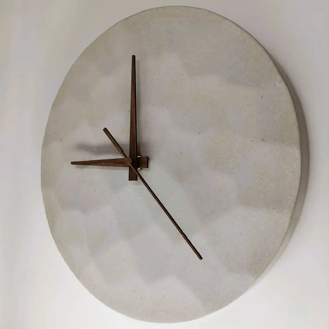 lautlose Wanduhr aus Beton mit gehämmerter Optik und Uhrzeigern aus Holz